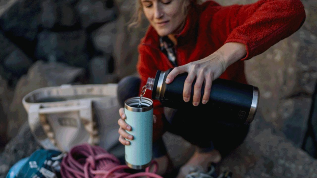 This is a link to CNN page of YETI best products and the image shows a woman pouring water from a yeti bottle into a yeti tumbler